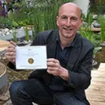 Professor Nigel Dunnett proudly displays the gold medal for the RBC Blue Water Roof Garden